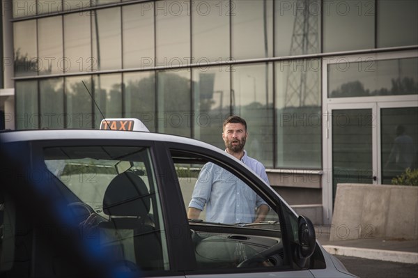 Caucasian man walking towards taxi