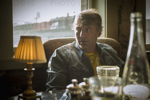 Caucasian man sitting at table near window