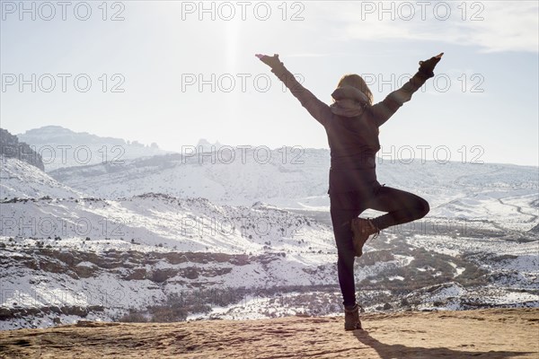Caucasian woman practicing yoga on remote hilltop