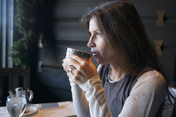 Caucasian woman drinking coffee in cafe