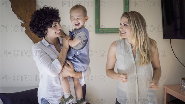 Caucasian lesbian mothers and baby son in living room