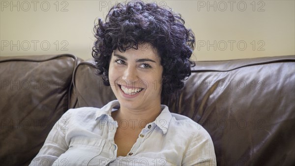 Caucasian woman smiling on sofa