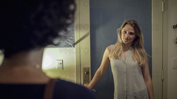 Caucasian lesbian couple standing in hallway