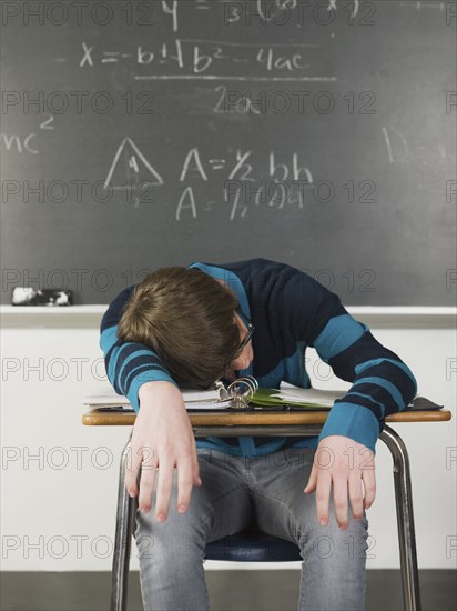 Student sleeping at desk in classroom