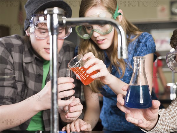 Students performing experiment in science lab classroom