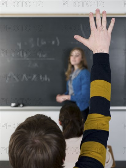 Student raising hand in classroom