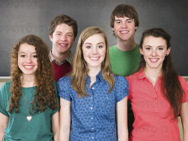 Students smiling by chalkboard in classroom