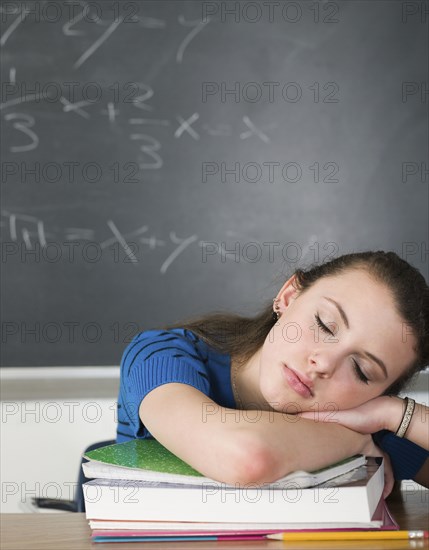 Bored student sleeping at desk in classroom