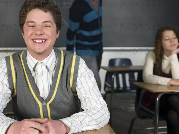 Student smiling at desk in classroom