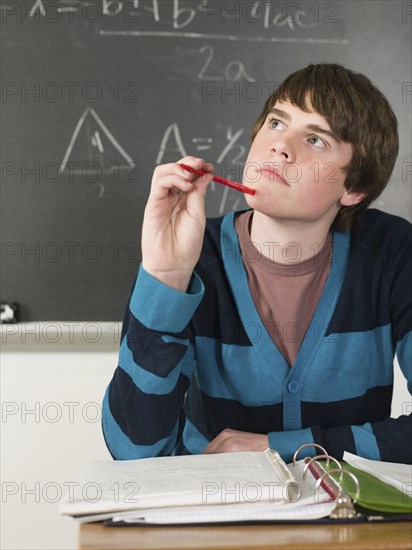 Student thinking at desk in classroom