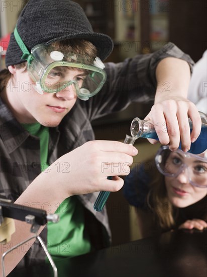 Students performing experiment in science lab classroom