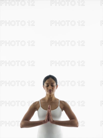 Serene woman meditating with hands clasped