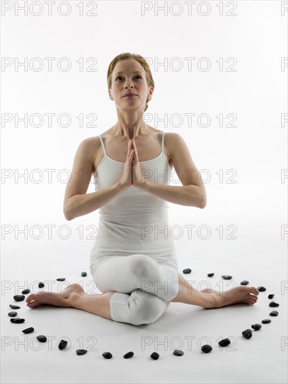 Caucasian woman meditating in ring of stones