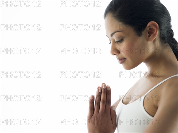 Serene woman meditating with hands clasped