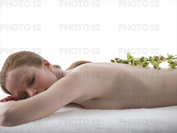 Caucasian woman having massage with flowers