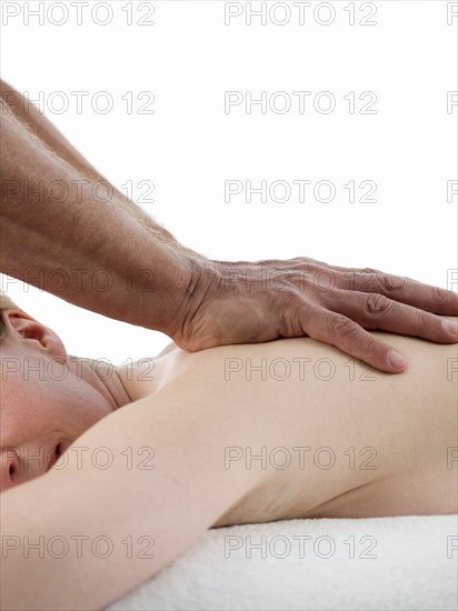 Close up of masseuse massaging shoulder of woman