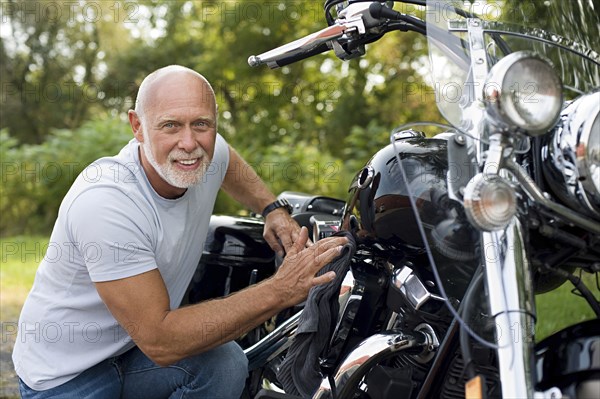 Older man repairing motorcycle