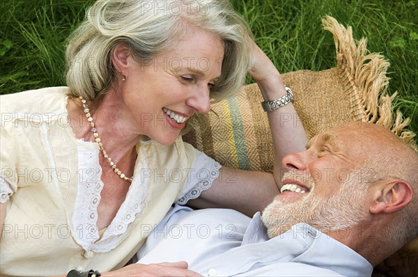 Older couple laying on picnic blanket