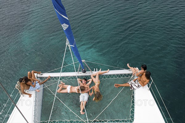 High angle view of friends sunbathing on sailboat