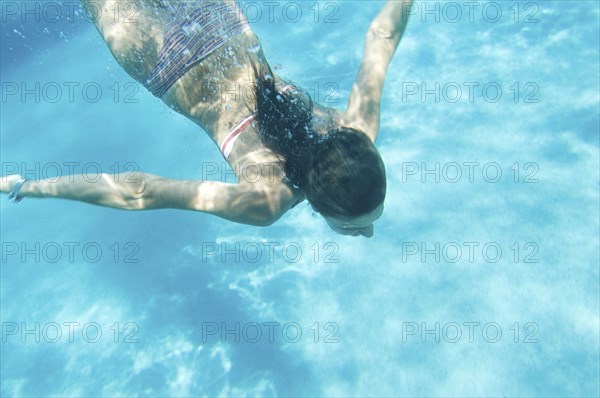 Underwater view of woman swimming in ocean