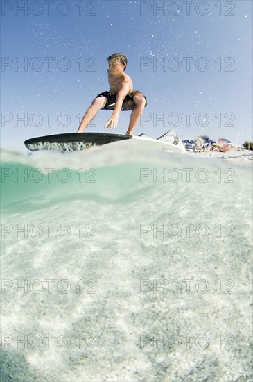 Low angle view of man standing on surfboard