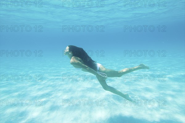 Underwater view of woman swimming in ocean