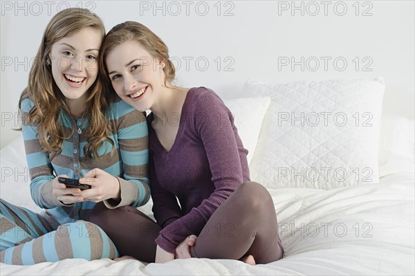 Caucasian women hugging on bed