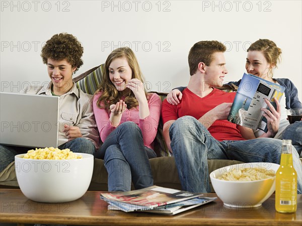 Friends relaxing on sofa in living room