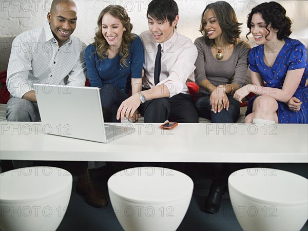 Business people using laptop in office lounge