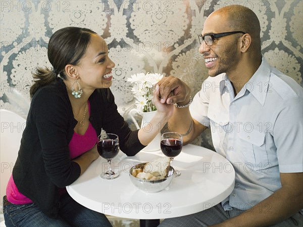 African American couple holding hands at restaurant