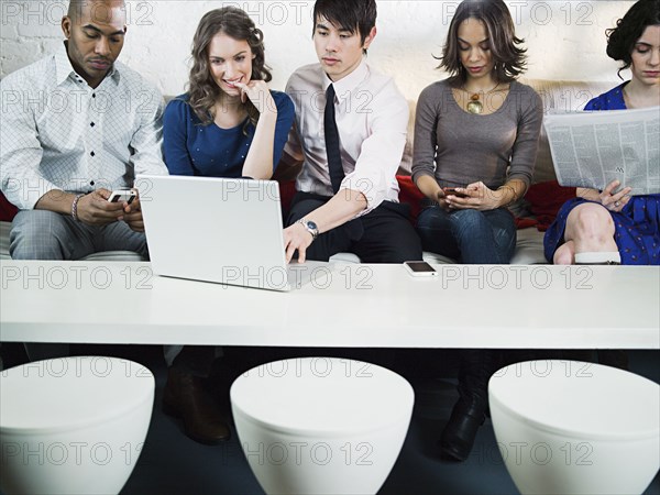 Business people using laptop in office lounge