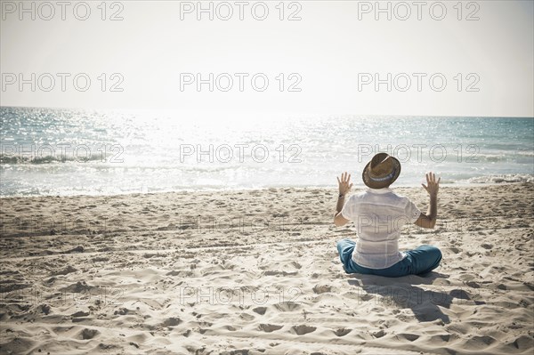 Caucasian man sitting on beach