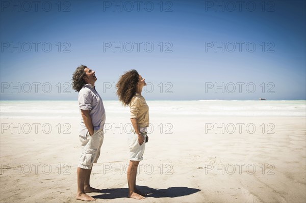 Couple standing in wind on beach