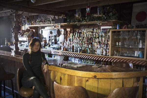 Caucasian woman sitting in empty bar