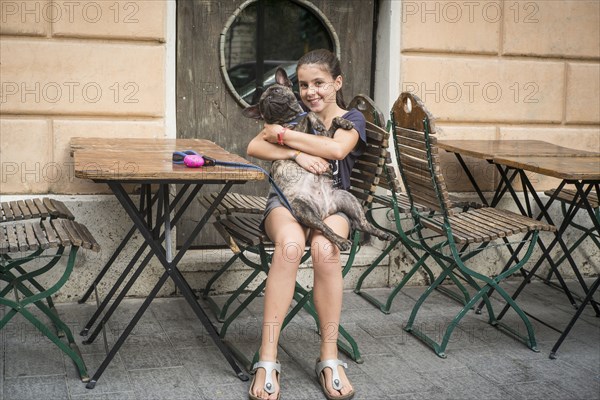 Caucasian girl hugging dog at cafe