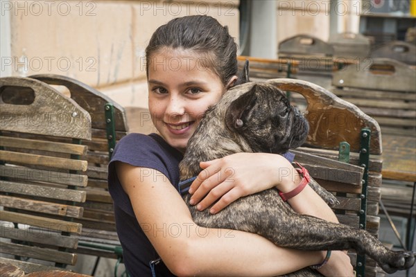 Caucasian girl hugging dog at cafe