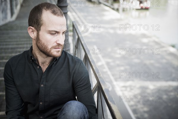 Caucasian man sitting on outdoor staircase