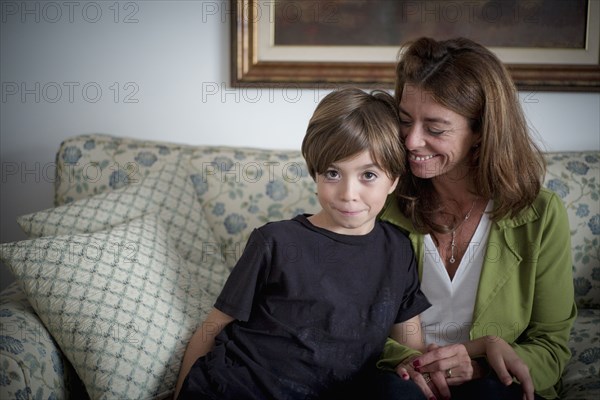 Caucasian grandmother and grandson sitting on sofa