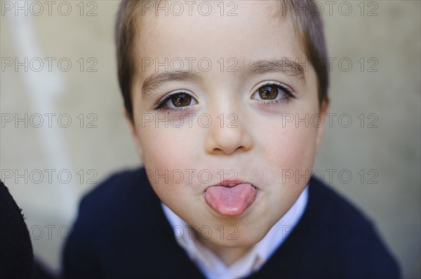 Caucasian boy sticking out tongue