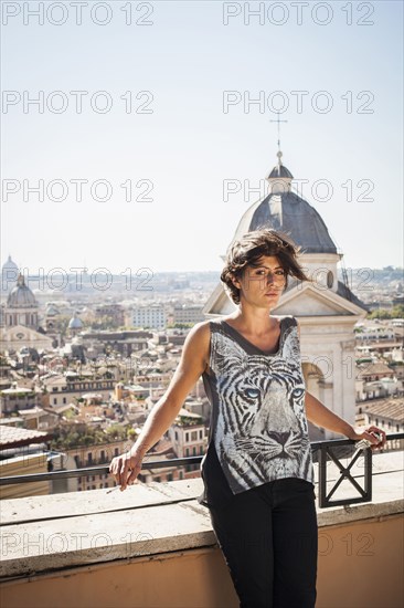 Caucasian woman standing on urban rooftop