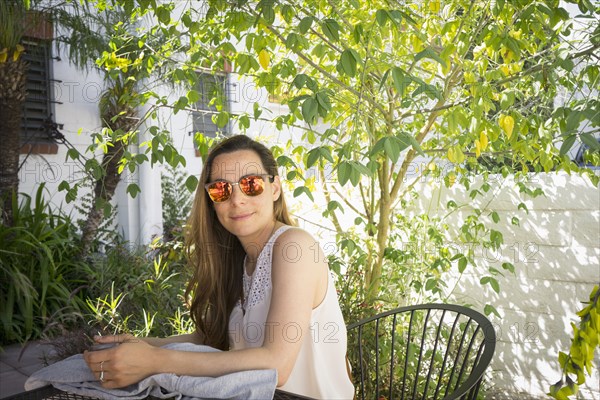 Caucasian woman sitting at table in garden