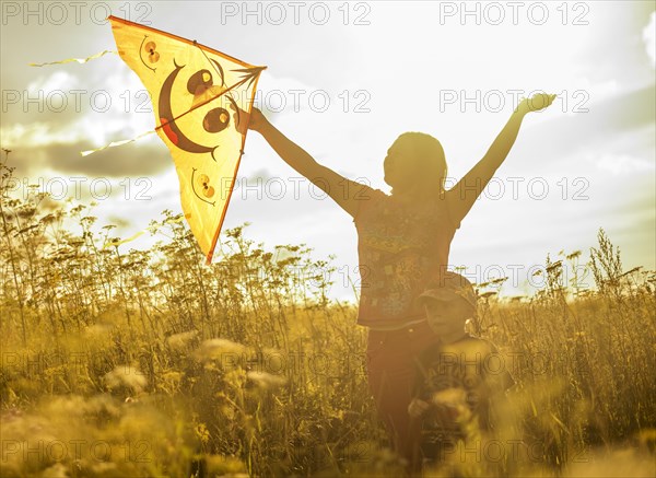 Caucasian mother and son flying kite in rural field