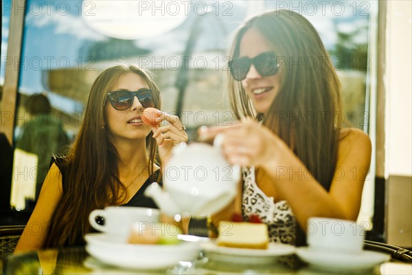 Women having coffee together at sidewalk cafe