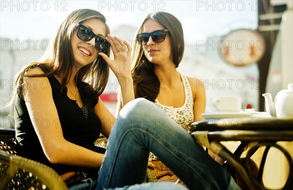 Women sitting together at sidewalk cafe