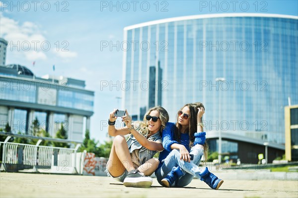 Women taking picture on city street