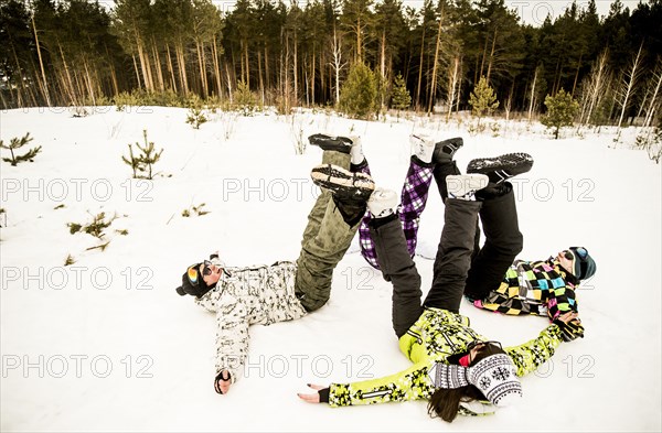 Caucasian couples playing together in snow