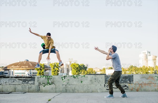 Caucasian men jumping in city