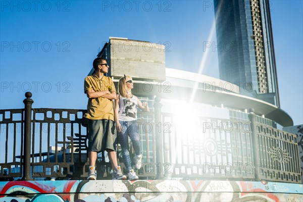 Caucasian couple standing near railing in city