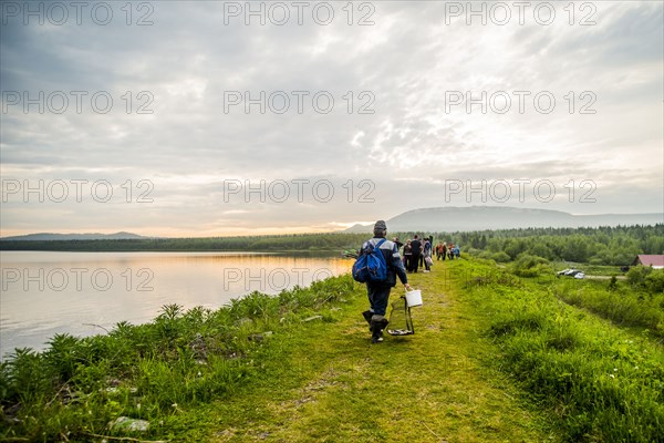 Caucasian campers walking near rural lake