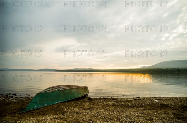 Dilapidated boat at rural lake